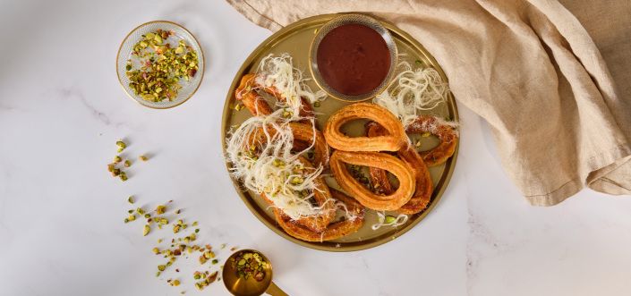 Churros su juoduoju šokoladu, pišmanijė chalva ir pistacijomis