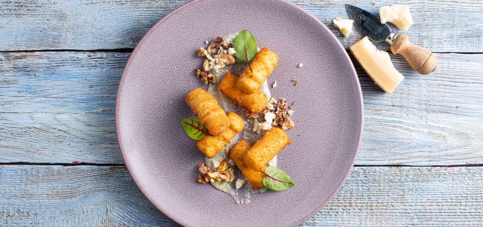 Bulvių kroketai, patiekiami su keturių sūrių ir skrudintų graikinių riešutų padažu