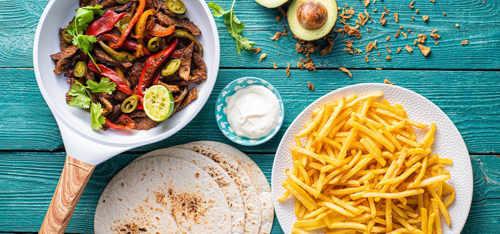 Jautienos fajita su svogūnais, paprikomis, grietine ir plonomis bulvytėmis fri